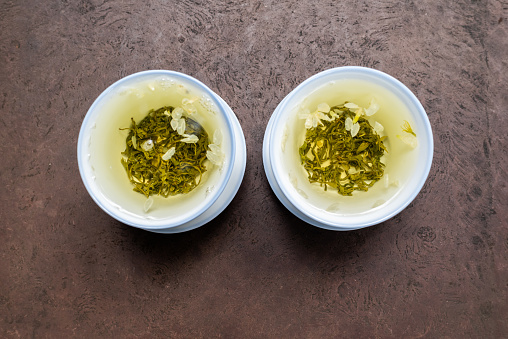 Two cups of green tea on a stone table close-up high angle iew