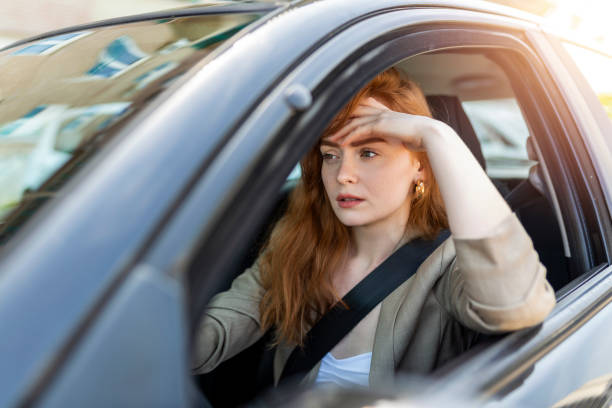 istock Nervous female driver sits at wheel, has worried expression as afraids to drive car by herself for first time. Frightened woman has car accident on road. People, driving, problems with transport 1402995659