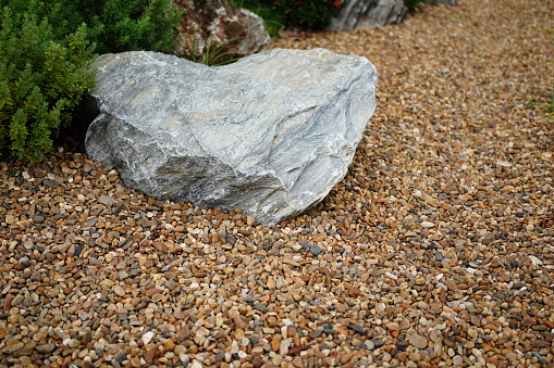 A plot of a Garden with stones and plant bushes