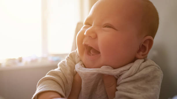 linda niña recién nacida sonríe ampliamente sintiéndose feliz en casa - baby cute laughing human face fotografías e imágenes de stock