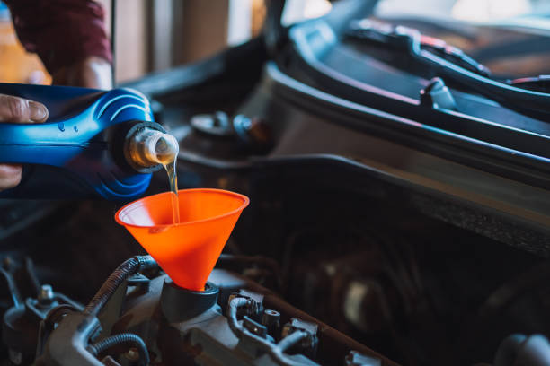 istock The mechanic pours new oil into the engine using funnel 1402998603