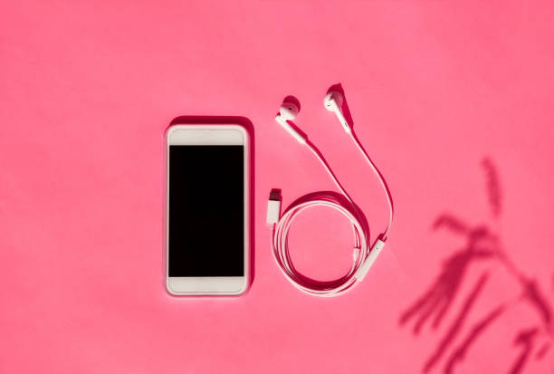 istock Smartphone and earphones on pink background 1402999062