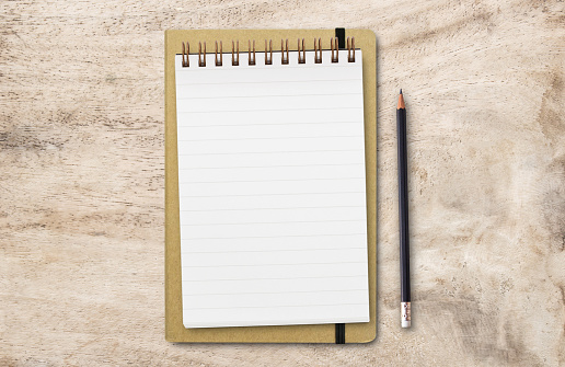 Flat lay top view with blank notepad and black pencil isolated on white backgroun.