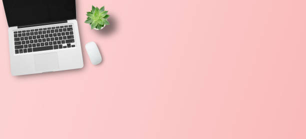 istock Top view with call center desktop, headset and accessories on pink table background. 1403004979