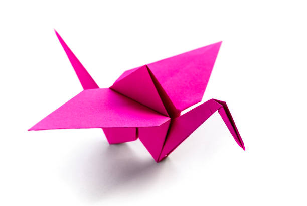 istock Pink paper crane origami isolated on a white background 1403005683