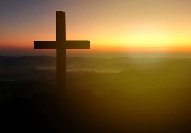 istock Silhouette christian cross on grass in sunrise background. 1403006001