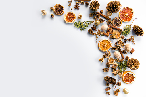 christmas decorations background with space for text of dried oranges, cinnamon and cones. white background