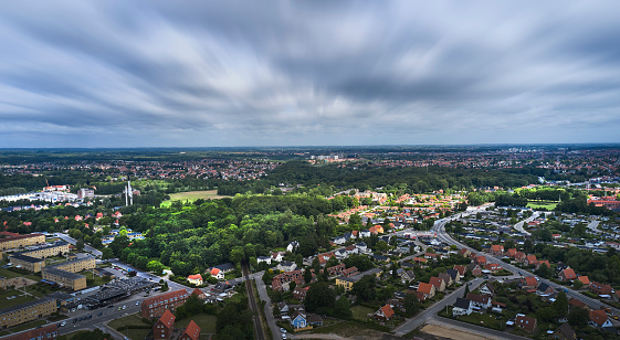 Residential district in Danish town. The sun breaks through the cloudy sky and lights up part of the landscape
