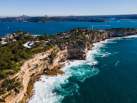 Aerial drone view of Watsons Bay in East Sydney, Australia looking toward South Head along the coastal clifftop on a sunny day