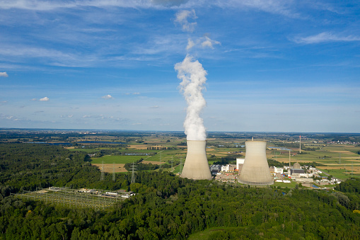 Energy Power Plant with chimneys and cooling towers with dramatic sky. Polluting clean air showing climate change concepts...global warming