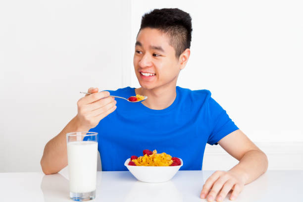istock Young adult eating cereal breakfast 1403011762