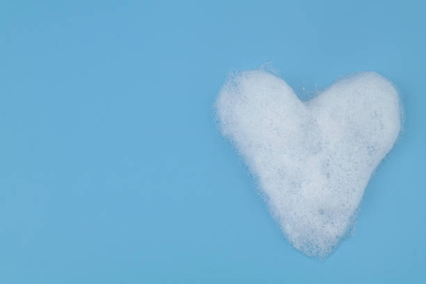 istock Heart from soap foam bubbles on blue background with copy space. 1403016774
