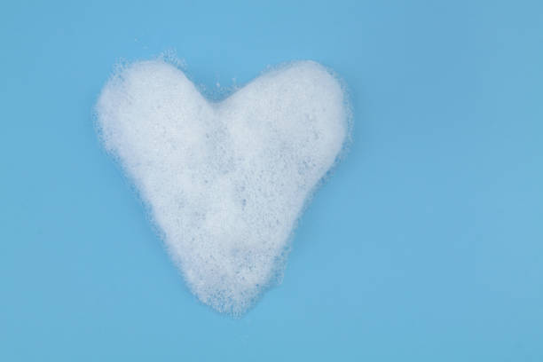 istock Heart from soap foam bubbles on blue background with copy space. 1403017328