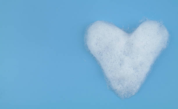 istock Heart from soap foam bubbles on blue background with copy space. 1403017343
