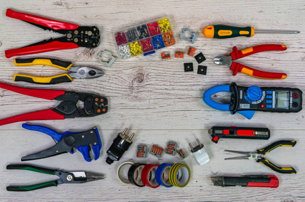 Professional electrician tools and electrical components on light wooden boards Professional electrician tools and electrical components on light wooden boards. Pliers, strippers, crimpers, multimeter, tester, screwdriver. Top view. wire cutter stock pictures, royalty-free photos & images