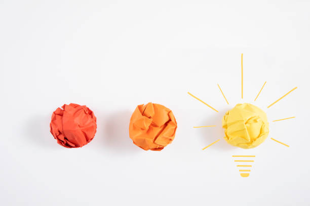 Idea concept with crumpled paper balls and pencil on white