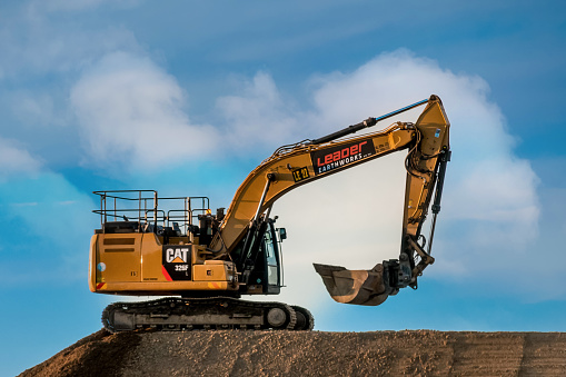 Singleton Australia 2022-04-21 Cat yellow heavy machinery excavator digger on a road construction site.