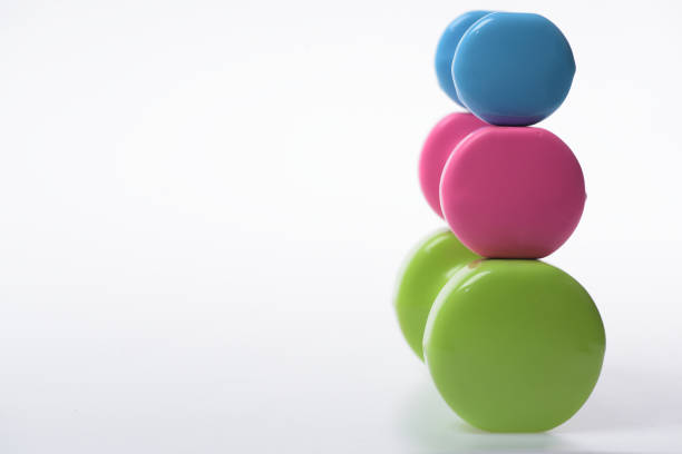 istock Dumbbells made of blue, pink and green plastic on white 1403020396