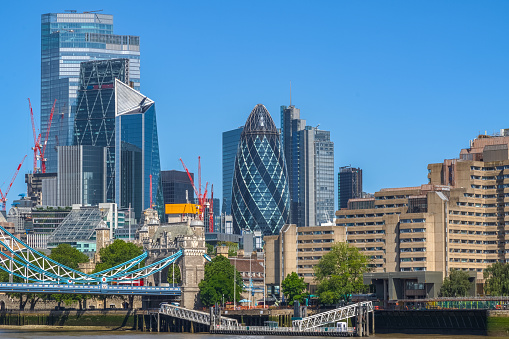Cityscape of financial district in London with new developments against blue cloudless sky