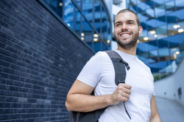 Free Stock Photo of Man With Backpack Standing in Front of Building ...