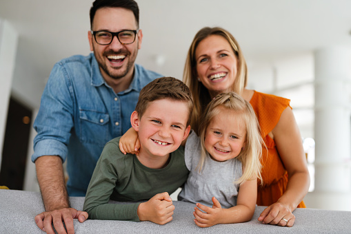 Happy young family having fun time at home. Parents children love happiness concept.