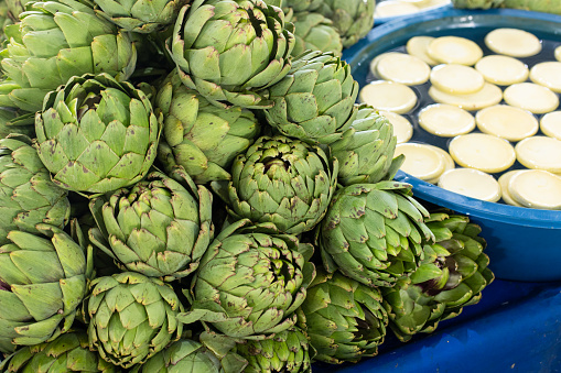 supermarket, italian price tag on fresh artichokes with selective focus in an open farmers market in Italy. fresh and ripe artichoke on vegetable stands or displays in greengrocery in Rome, Italy