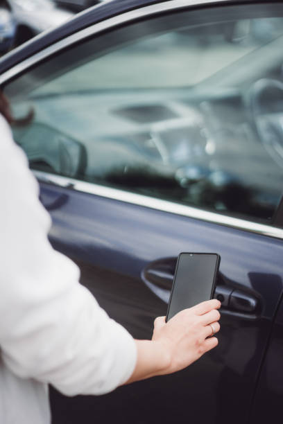 istock young woman uses mobile phone to open intelligence car 1403025592