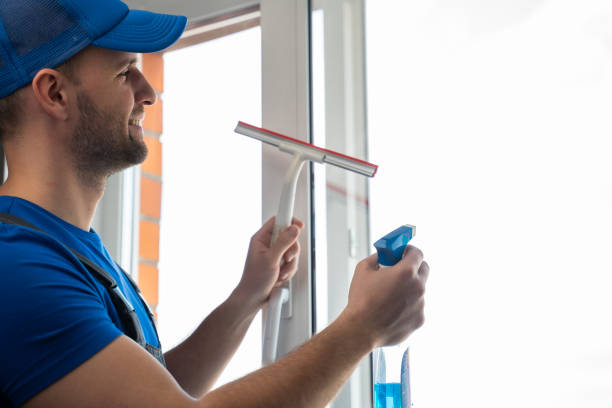 istock Man cleans plastic window glass with detergent and squeegee 1403025967