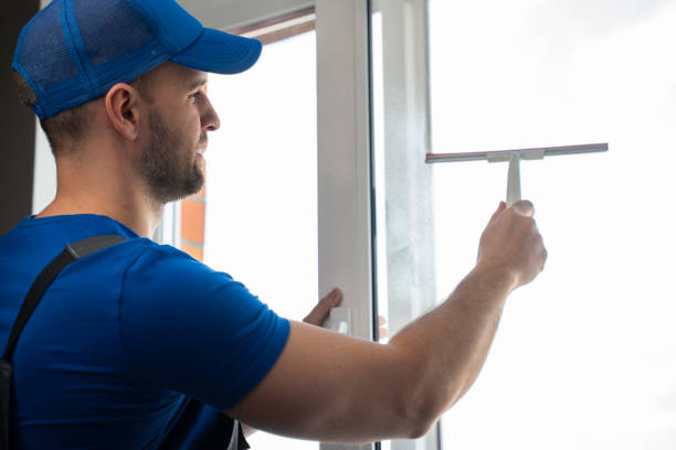 istock Man cleans plastic window glass with detergent and squeegee 1403026128