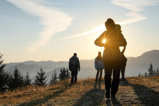 Tourists with backpacks in mountains on sunset