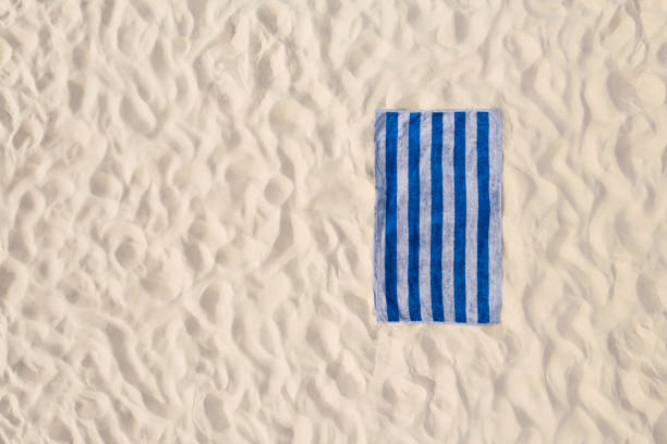 Striped beach towel on sand, aerial view. Space for text