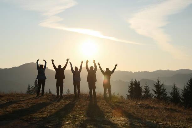 istock Group of people enjoying sunrise in mountains, back view 1403027064