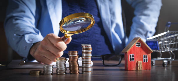 istock Real estate agent holding magnifying glass on house model. 1403027093