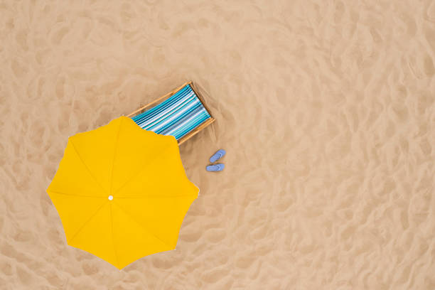 istock Yellow beach umbrella, sunbed and flip flops on sandy coast, aerial view. Space for text 1403027164