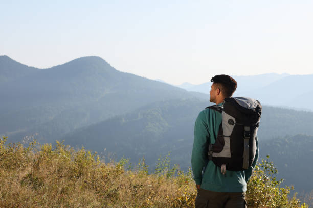 istock Tourist with backpack in mountains on sunny day, back view. Space for text 1403027221