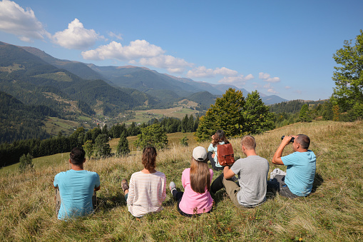 Group of people spending time together in mountains, back view
