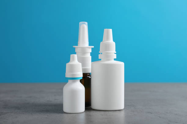 istock Nasal sprays in different bottles on grey table against light blue background 1403029001