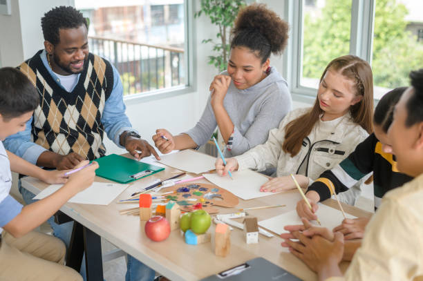 istock group of students studying and playing with teacher, education and learning concept. 1403029043
