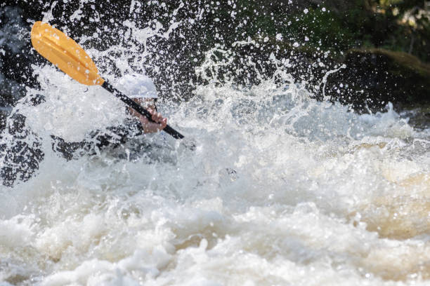 istock Kayak racing through the freshwater rapids dramatically submerging the Kayaker. 1403029887