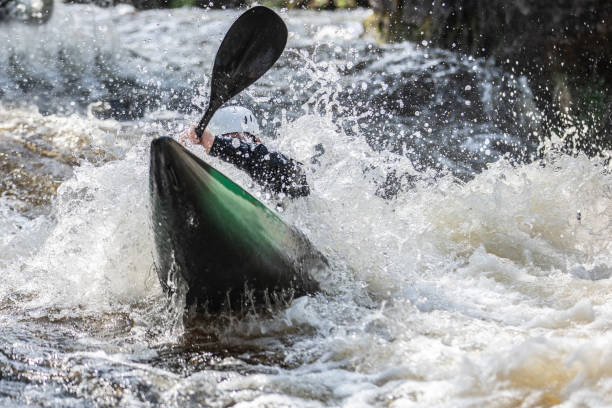 istock Kayak racing through the freshwater rapids dramatically submerging the Kayaker. 1403029974