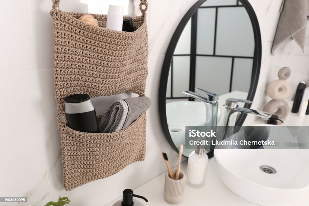 Knitted organizer hanging on wall in bathroom Bathroom Stock Photo