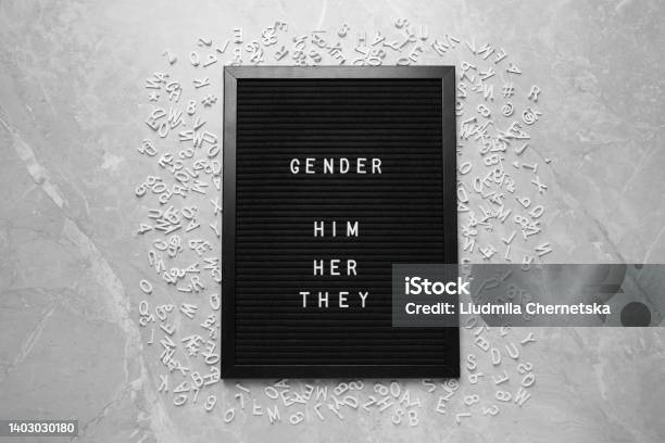 Black Board With Words Gender Him Her They And Letters On Grey Marble Table Flat Lay Stock Photo - Download Image Now