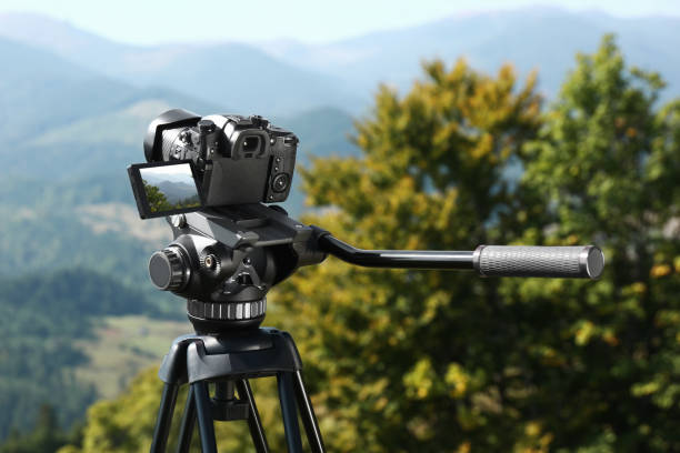 istock Tripod with modern camera in mountains on sunny day 1403030230