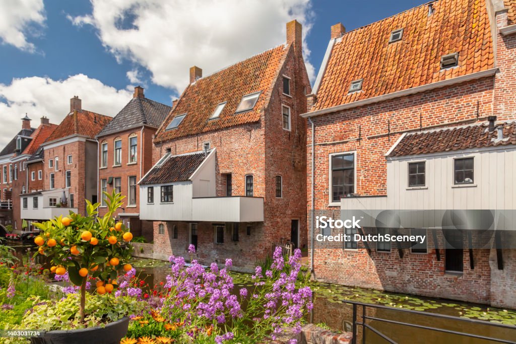 Dutch medieval houses with hanging kitches at the Damsterdiep canal in Appingedam, Groningen, The Netherlands Summer view of Dutch medieval houses with hanging kitches at the Damsterdiep canal in Appingedam, Groningen, The Netherlands Groningen Province Stock Photo