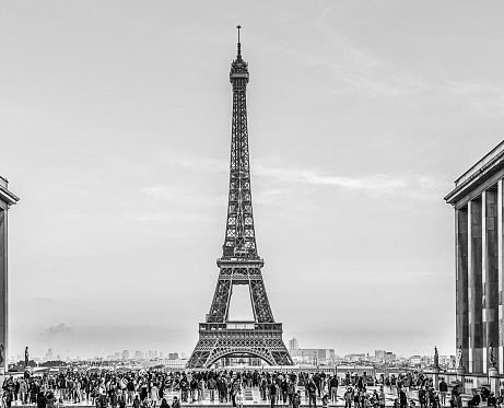 Black and white photography of the Eiffel tower with a crowd of tourists