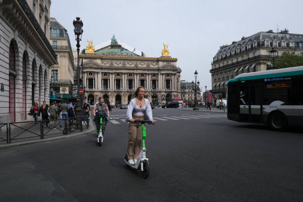 People ride electric scooters People ride electric scooters  in front of Opera in Paris, France on APril 23, 2022. lime scooter stock pictures, royalty-free photos & images