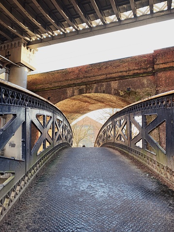 Footbridge over the canal and under the rail bridges in Deansgate, Manchester