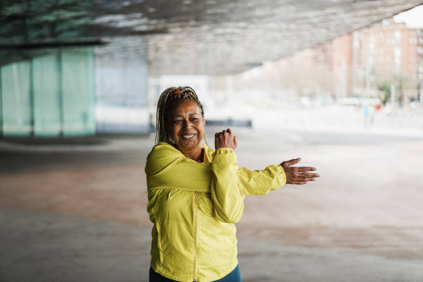 istock Senior african woman stretching during workout routine outdoor - Focus on face 1403037284