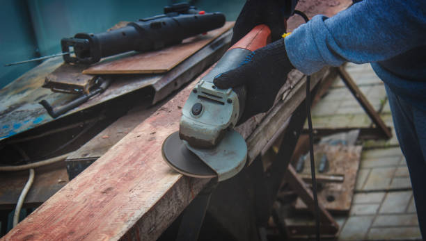 istock a man is grinding a board. Removing old paint from boards. Carpentry work. 1403039036