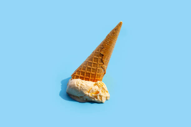 istock Melting ice cream balls with waffle cone on blue background. 1403039069